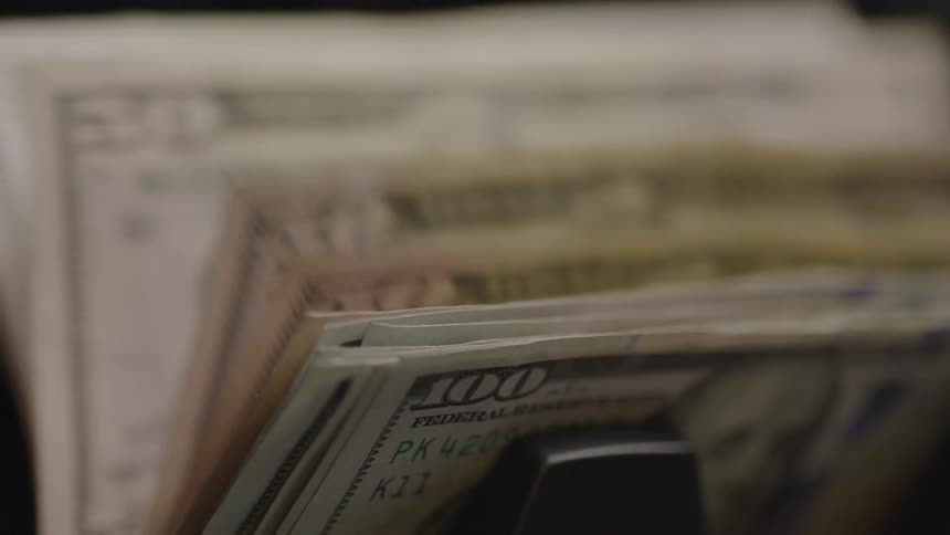 Close up of a paper currency bundle counted by an electronic bill counter