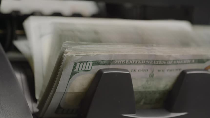 Close up of counting machine counting a stack of hundred dollar bills