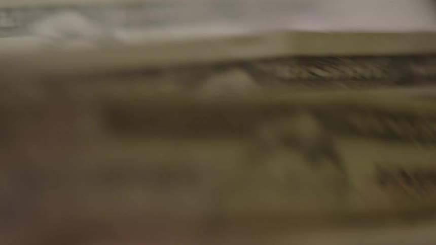 Close up of a stack of cash being flipped very fast