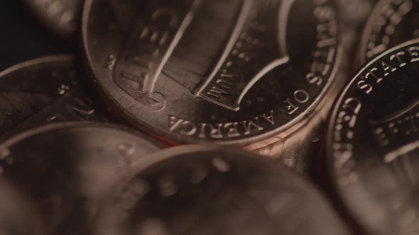 Close up of different bronze bank coins scattered on a table surface