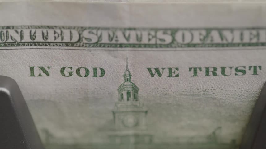 The money counter flips the bills into a stack