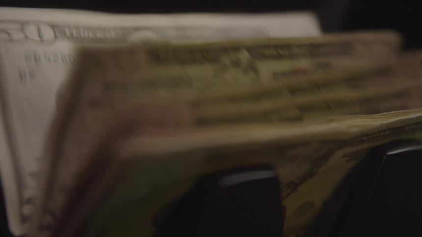 A large amount of us bills is dispensed from an atm