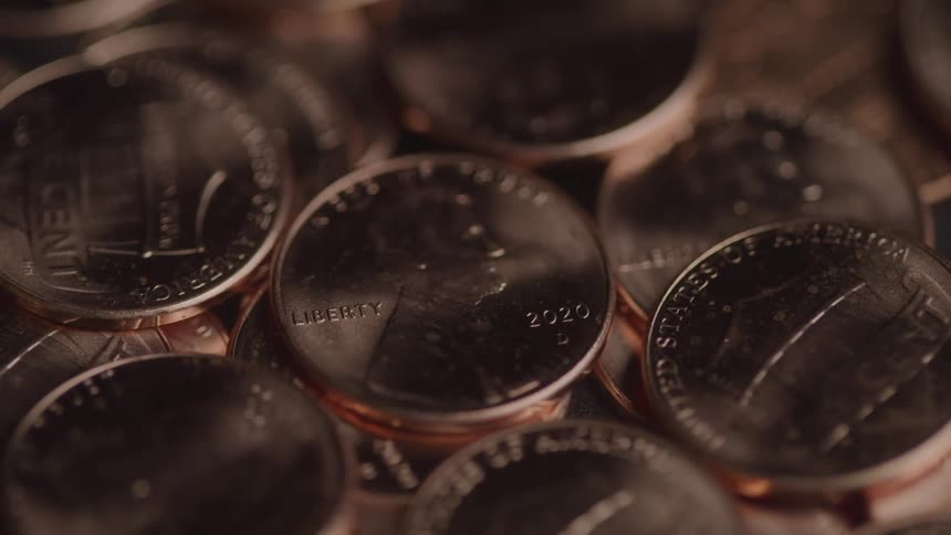 A closeup shot of shiny copper pennies stacked and scattered together