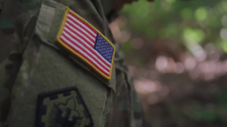 The soldier has an american flag patch on their uniform