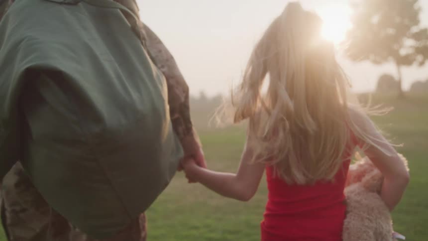 A mother and daughter walk while holding hands