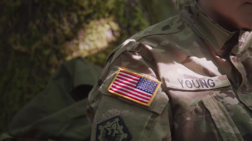 A solider sits under a tree