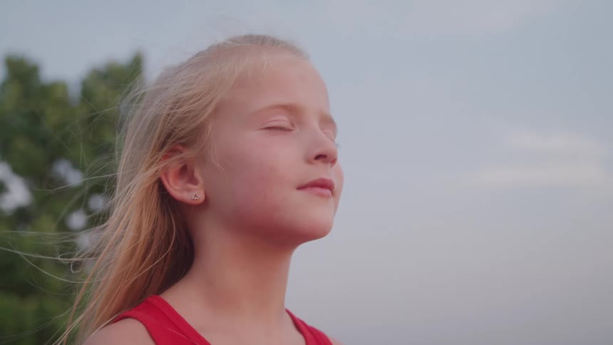 Blonde girl outdoors with eyes closed