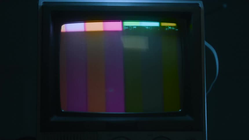 A television flashes a broken screen display in bright colors