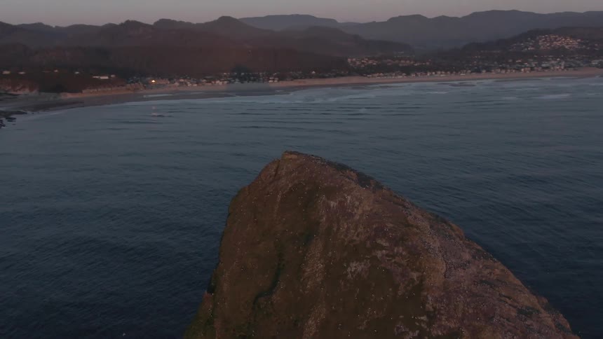 Coastal landscape with ocean and mountains at dusk