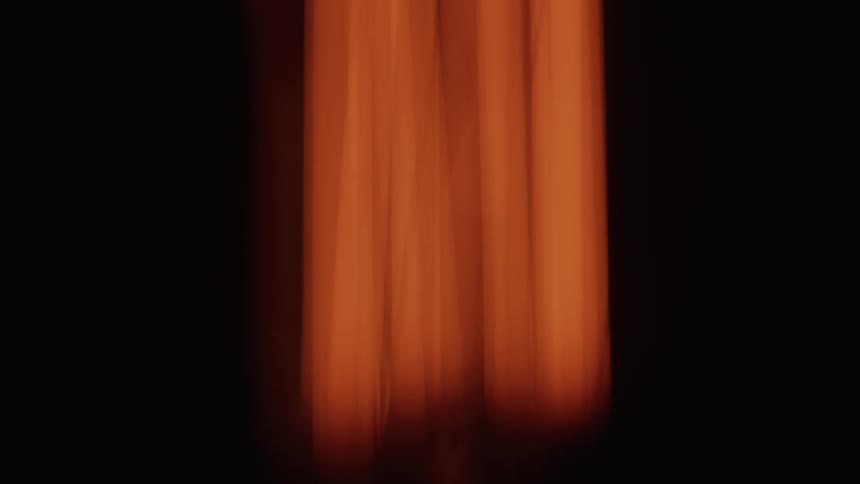 The camera lens blurs the orange curtain