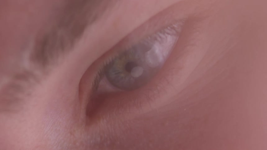 A soft focused extreme closeup of a human eye looking sideways