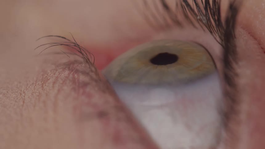 An extreme closeup of a human eye looking upward