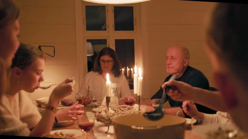 Family sitting around a table having a dinner of soups with wine