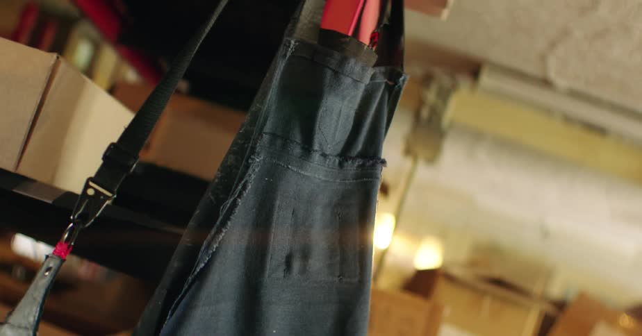 Black apron hanging on a shelf