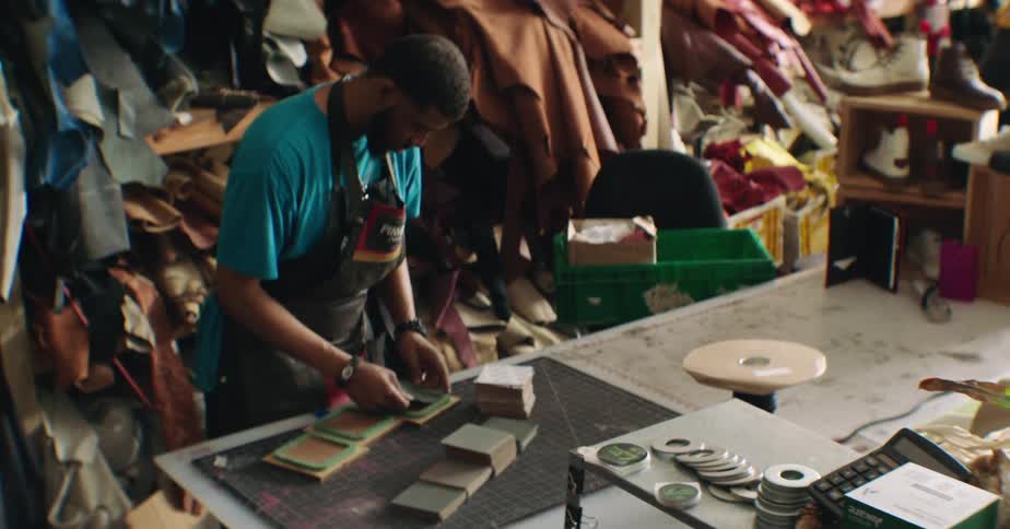 Craftsman man in an apron handling fabrics