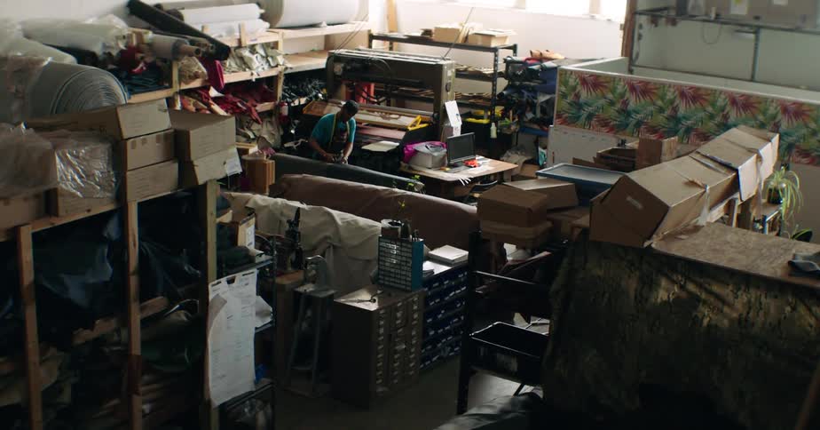 Man working in a factory with fabrics on manual machines