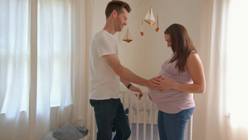 A man is touching his pregnant wifes belly