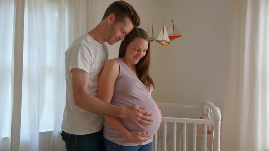 Couple hugging a pregnant woman