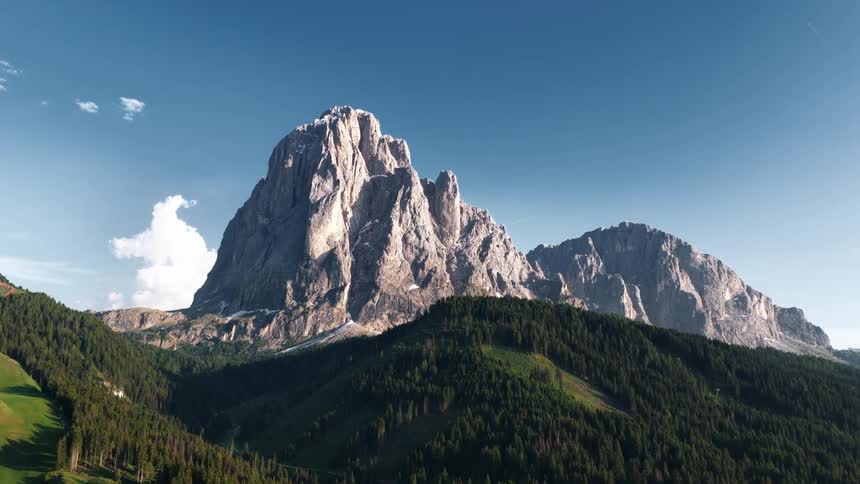 Aerial View of a Large Mountain Towering Over Surrounding Hills