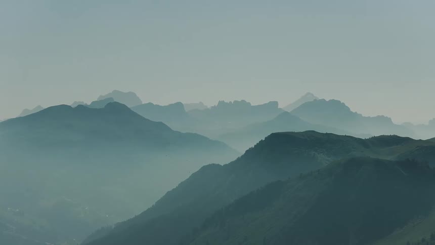 Aerial Clip of Mountains Covered in Fog Across the Landscape