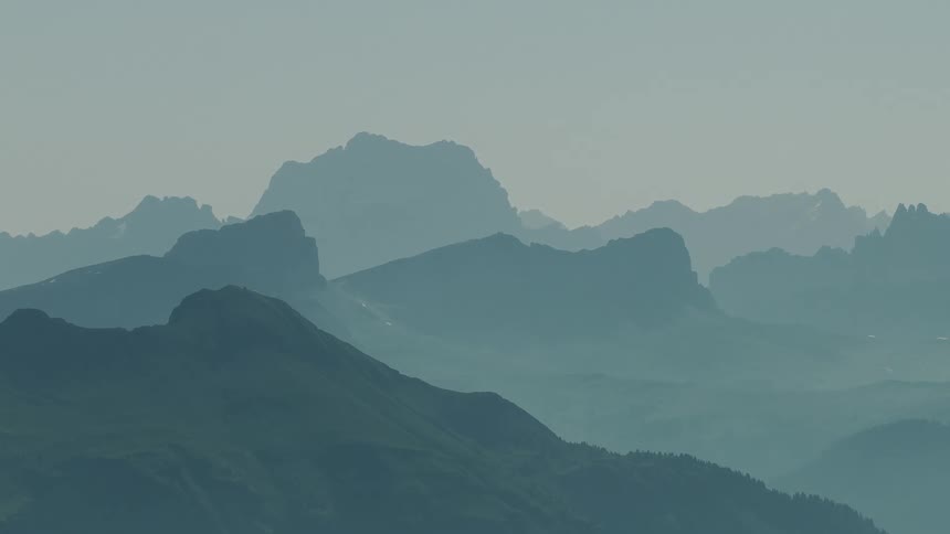 A mountain region is covered in a foggy atmosphere around midday
