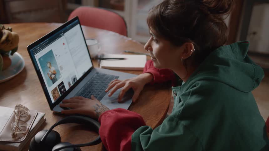 Woman sitting and interacting with a laptop