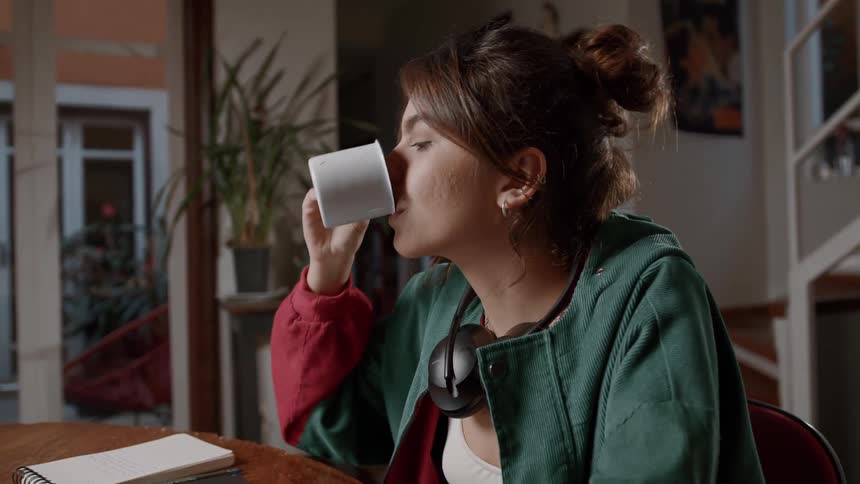 A woman is drinking coffee at home