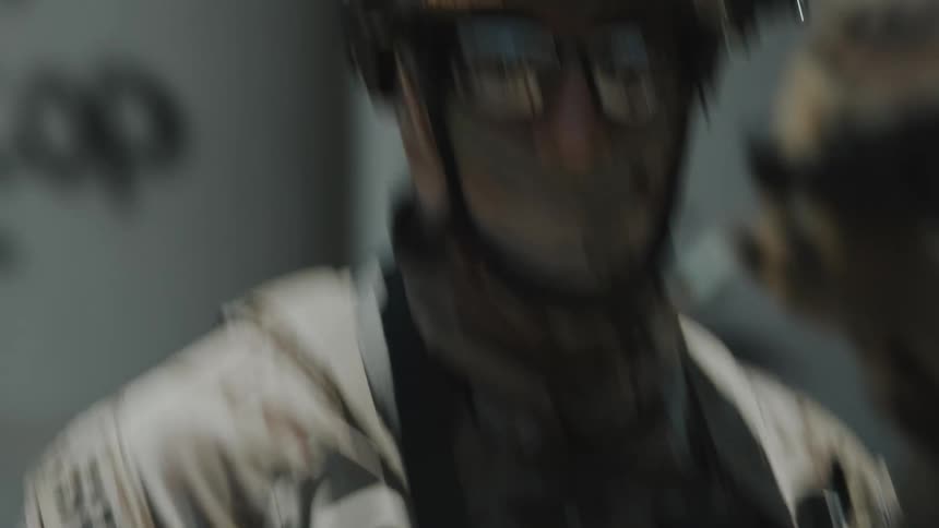 The officer is wearing a mask and camouflage