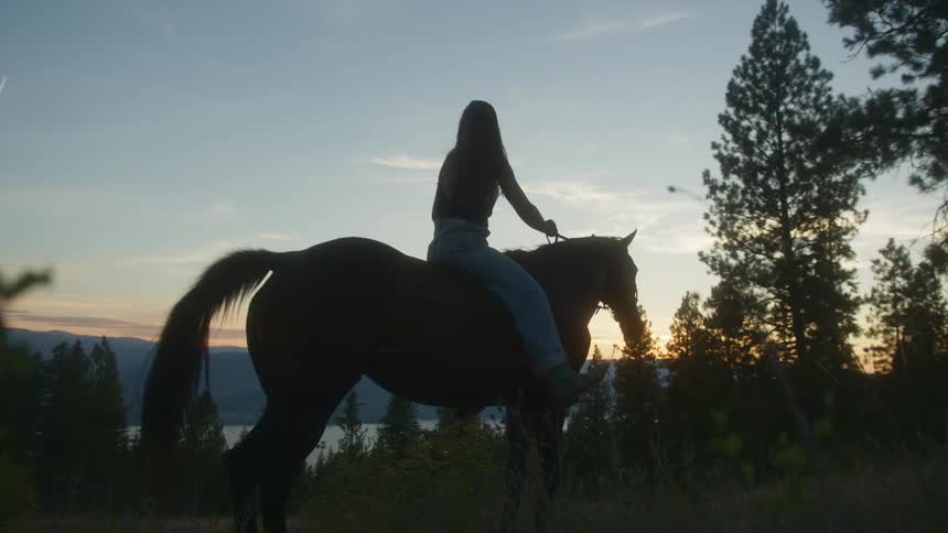 A woman is riding a horse without a saddle