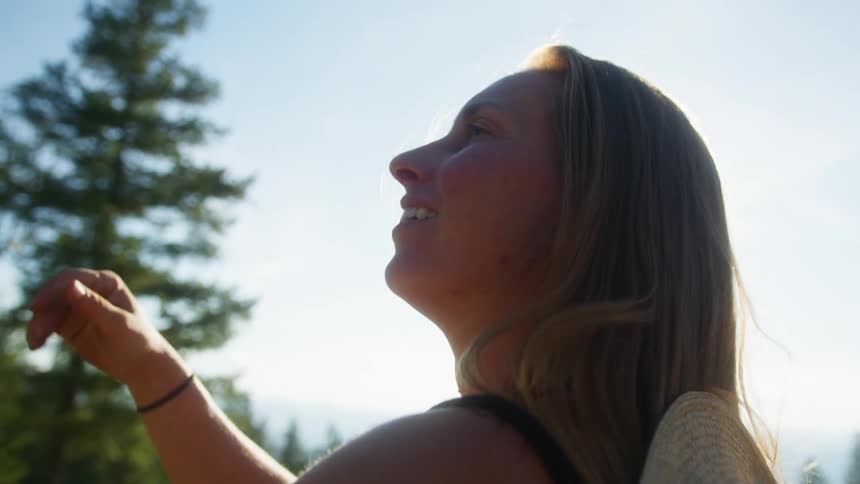 Smiling woman outdoors petting a horses face