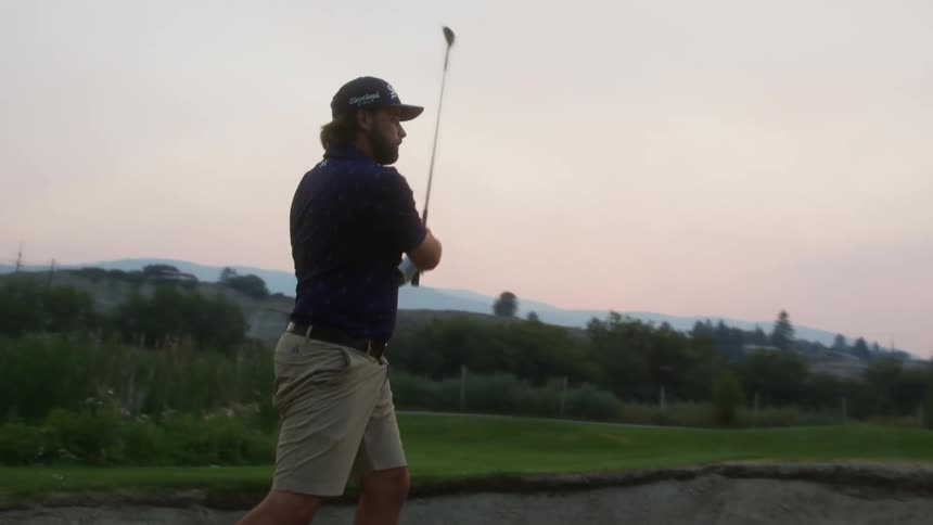The man hits the golf all out of the sand trap