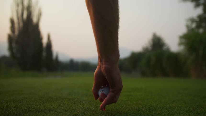 Golfer teeing up his ball on the greens of golf course