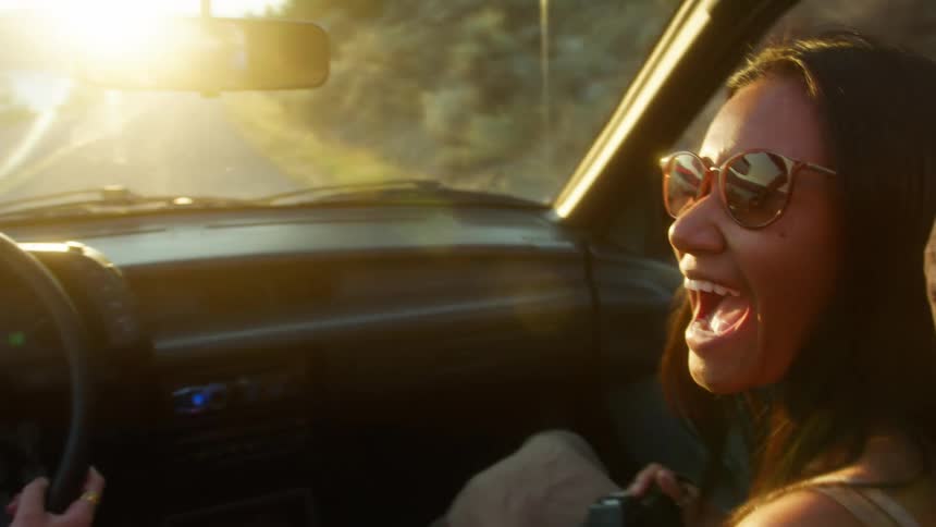 A woman riding passenger takes a photo of the driver