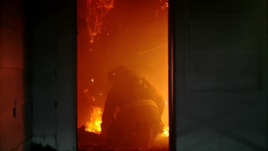 Firefighter inside a burning house at night