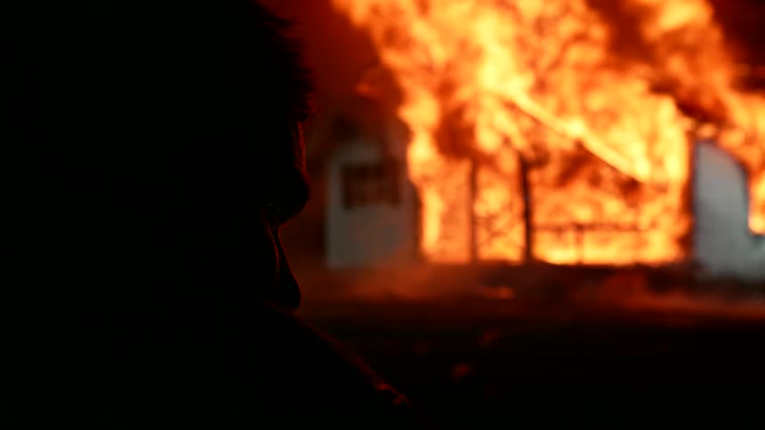 A man is watching the home burn
