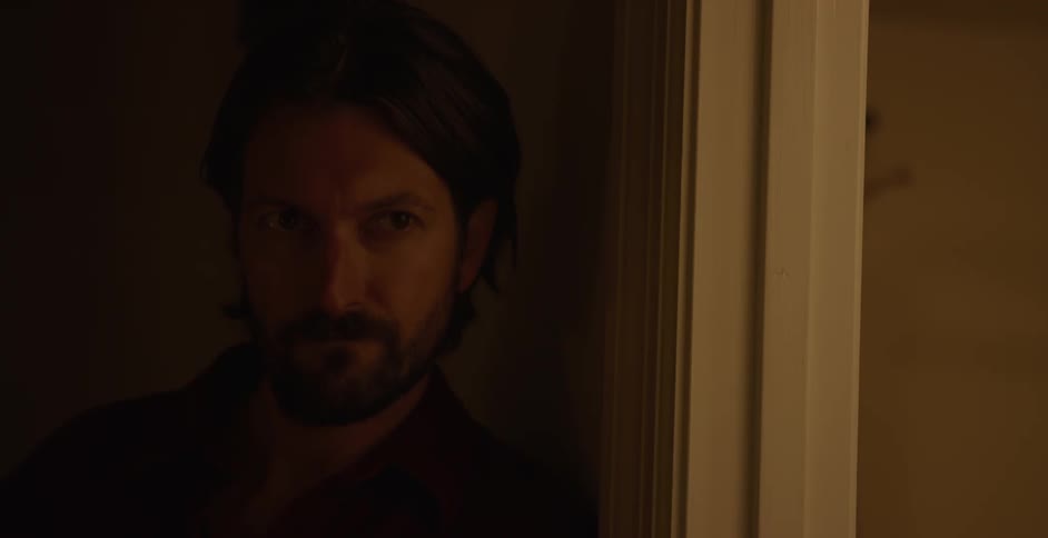 Man in a lowlit room of the house observing