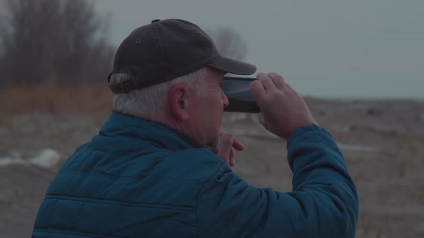 Man photographs the coast with his phone