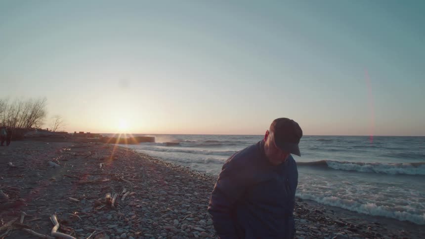Man in cap walking along the seashore on a winter day