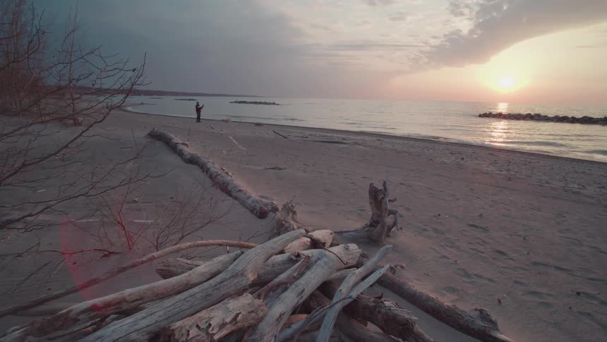 Person alone on a nude beach at dawn