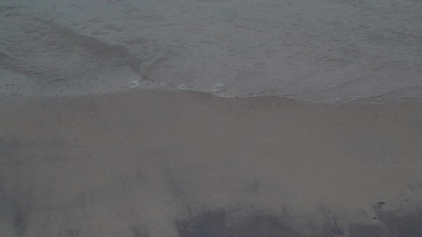 Waves crash along the shore of the beach
