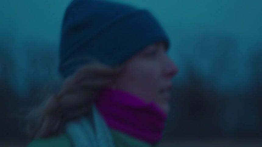 Woman in beanie and hat walking outdoors