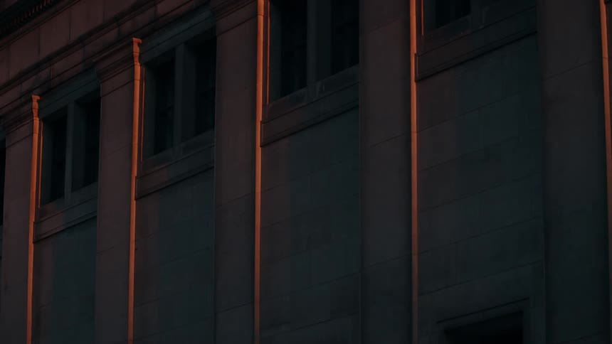Golden sunlight fades onto the walls of a stone building