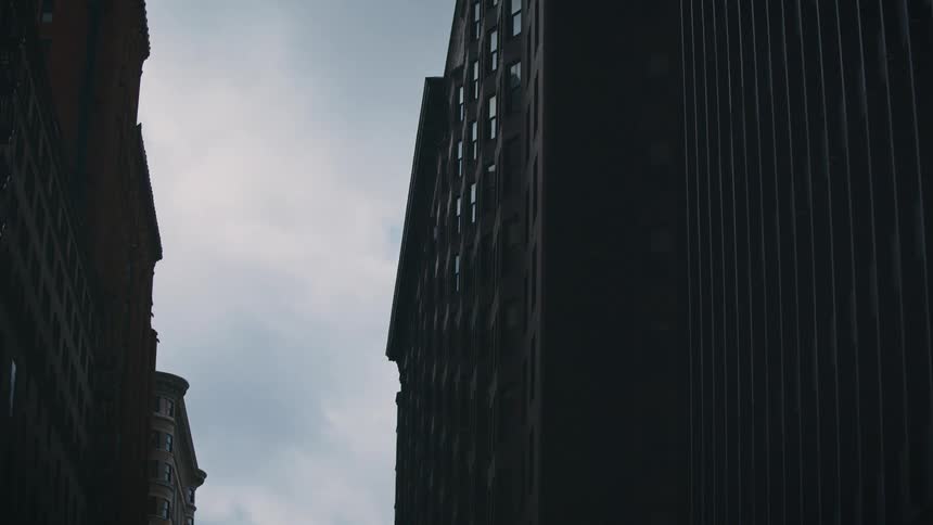 Time lapse of clouds moving between the buildings of a metropolis
