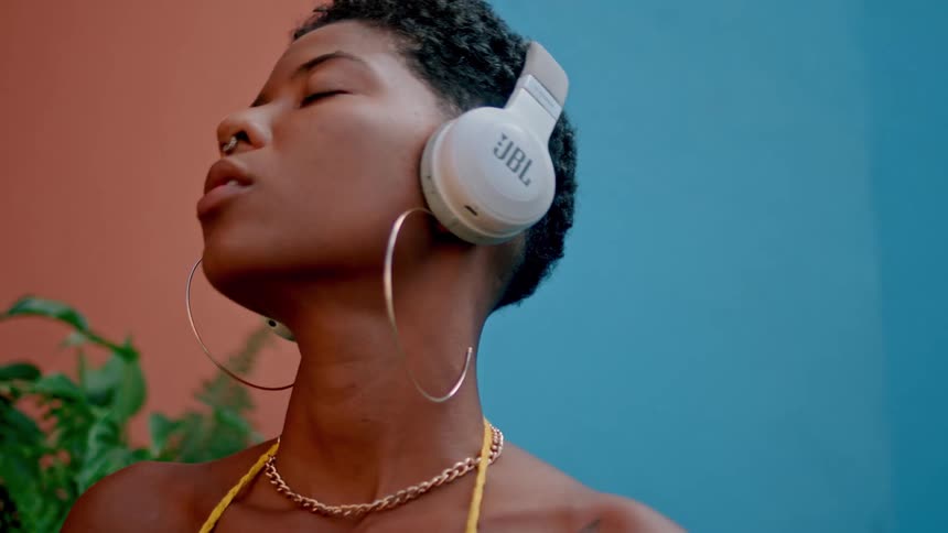 Woman with eyes closed enjoying music on headphones
