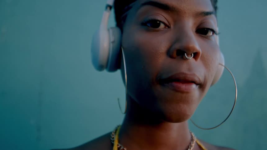Young woman with piercing and white headphones