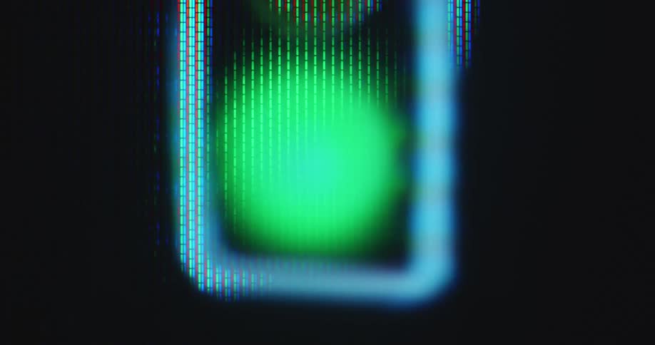 Macro closeup of the bright neon green light of a traffic light or signal shining and lighting up on a monitor as a symbol for a go or start signal for any type of process or a car race at the starting line