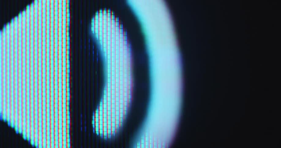 Extreme Macro close up of a pixelated computer or tube tv screen displaying a sound or speaker icon as the music or podcast is being played while being visualised by soundwaves moving forward