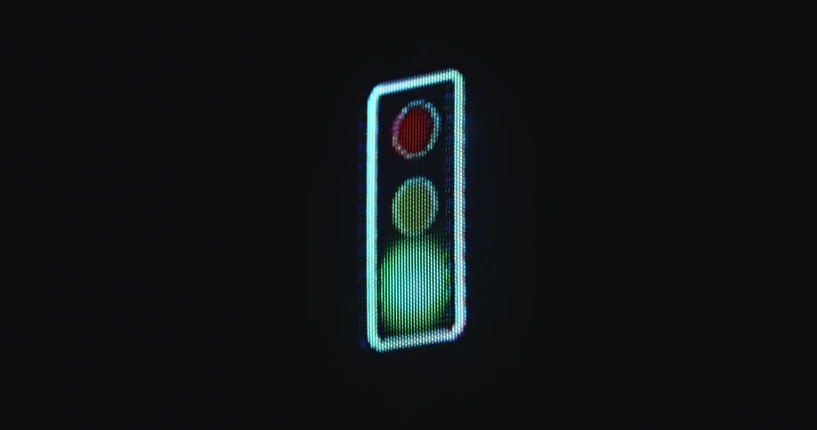 A glowing and brightly shining stoplight sign or American traffic light on a black background that is blinking red green and yellow while controlling the flow of online traffic in a digital urban environment with modern infrastructure