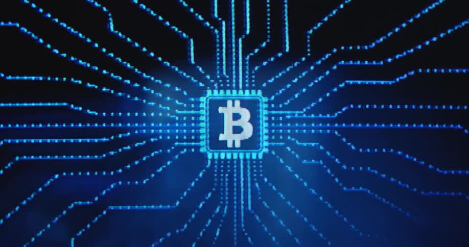 Blue moving lights form a data line pattern connecting at a computer chip on a printed circuit board with a white bitcoin logo at the center as symbol for servers and mining hardware running the BTC network with high energy consumption