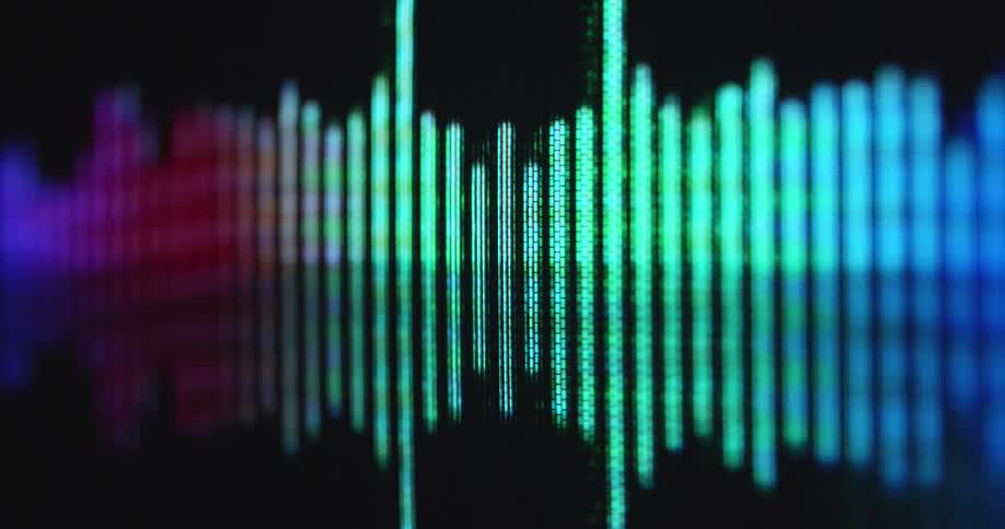 A multi-colored equaliser animation moves on a pixelated computer screen or display as the bars jump up and down visualizing the audio signal or voice recording of music or audio book or podcast